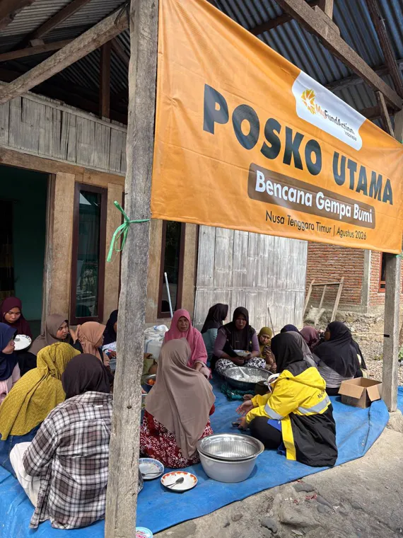 MyFundAction's main relief post in Nagekeo under its Posko Utama banner, with women cooking together in the community kitchen below
