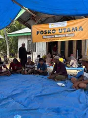 Families gathered beneath the Posko Utama banner at the relief post