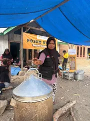 A MyFundAction team member at the community kitchen beside a cooking pot