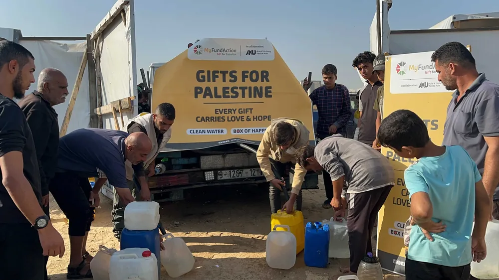 People filling water containers from a MyFundAction 'Gifts for Palestine' water truck in Gaza